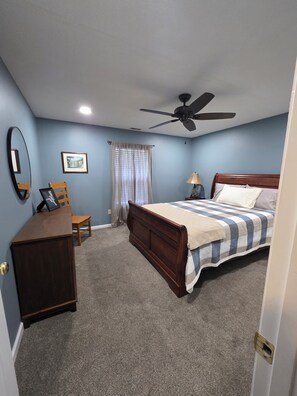 A bedroom with a bed, a desk, a chair, a ceiling fan, and a window with curtains. - Quiet 3-Bedroom Country Stay in Nebo, Illinois (Nebo)