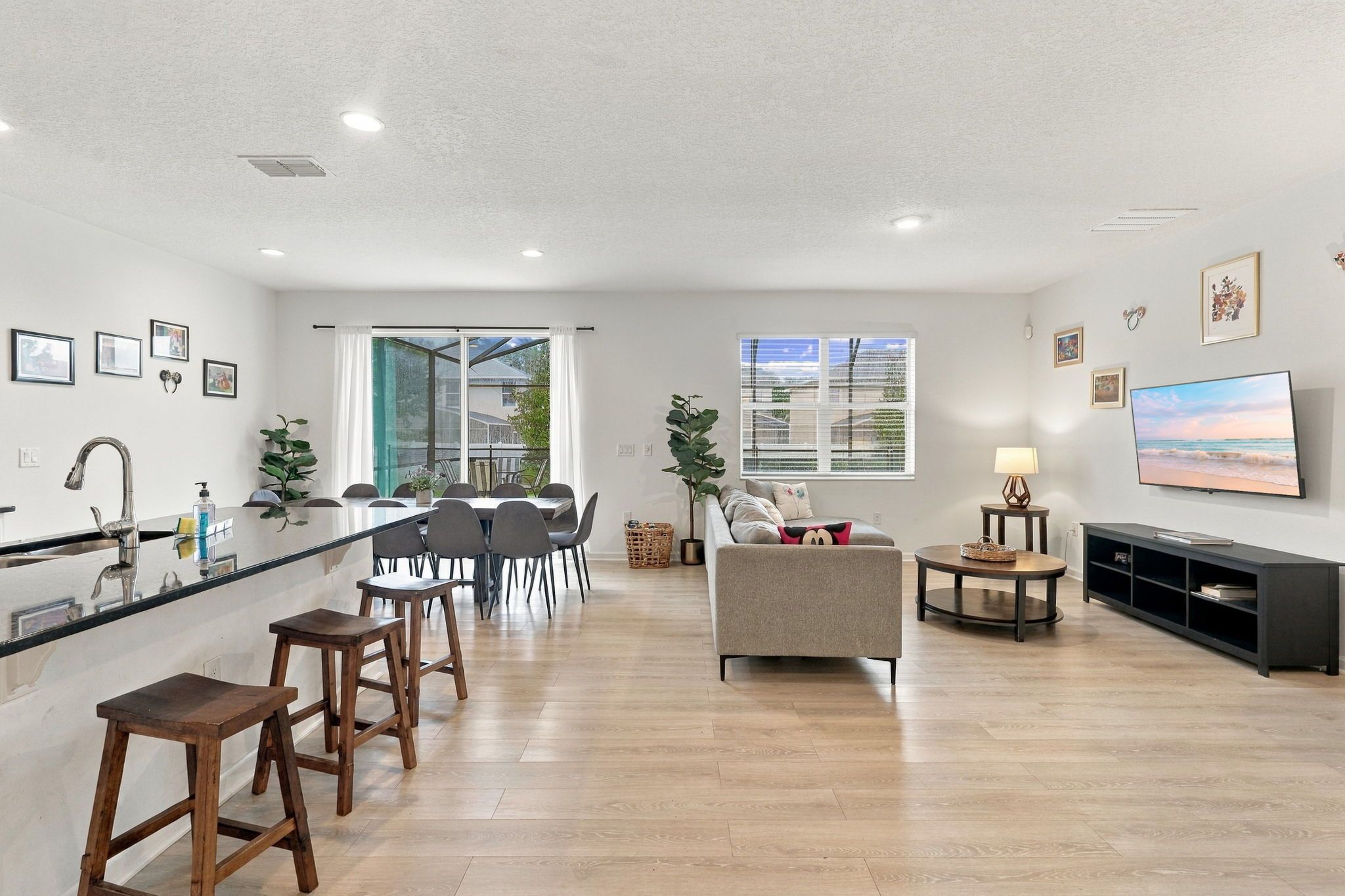 A spacious living area with a kitchen, dining area, and a large window providing a view.