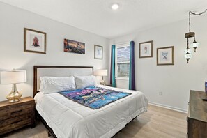 Ein Schlafzimmer mit einem Bett, Nachttischen und einem Wandbild.