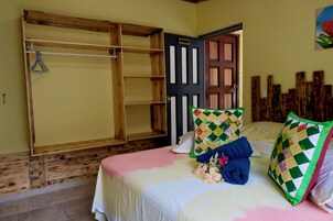 Un dormitorio con cama, armario de madera, puerta y pared con diseño de paneles de madera.