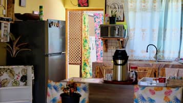 A kitchen with a refrigerator, stove, and various kitchen items.
