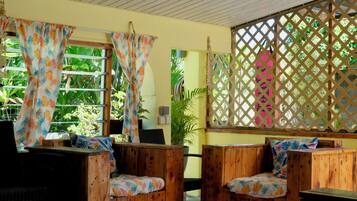 A room with wooden furniture, a window with curtains, and a lattice screen.