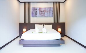 Een moderne slaapkamer met een groot bed, twee nachtkastjes met lampen, een kunstwerk aan de muur en een houten hoofdbord.