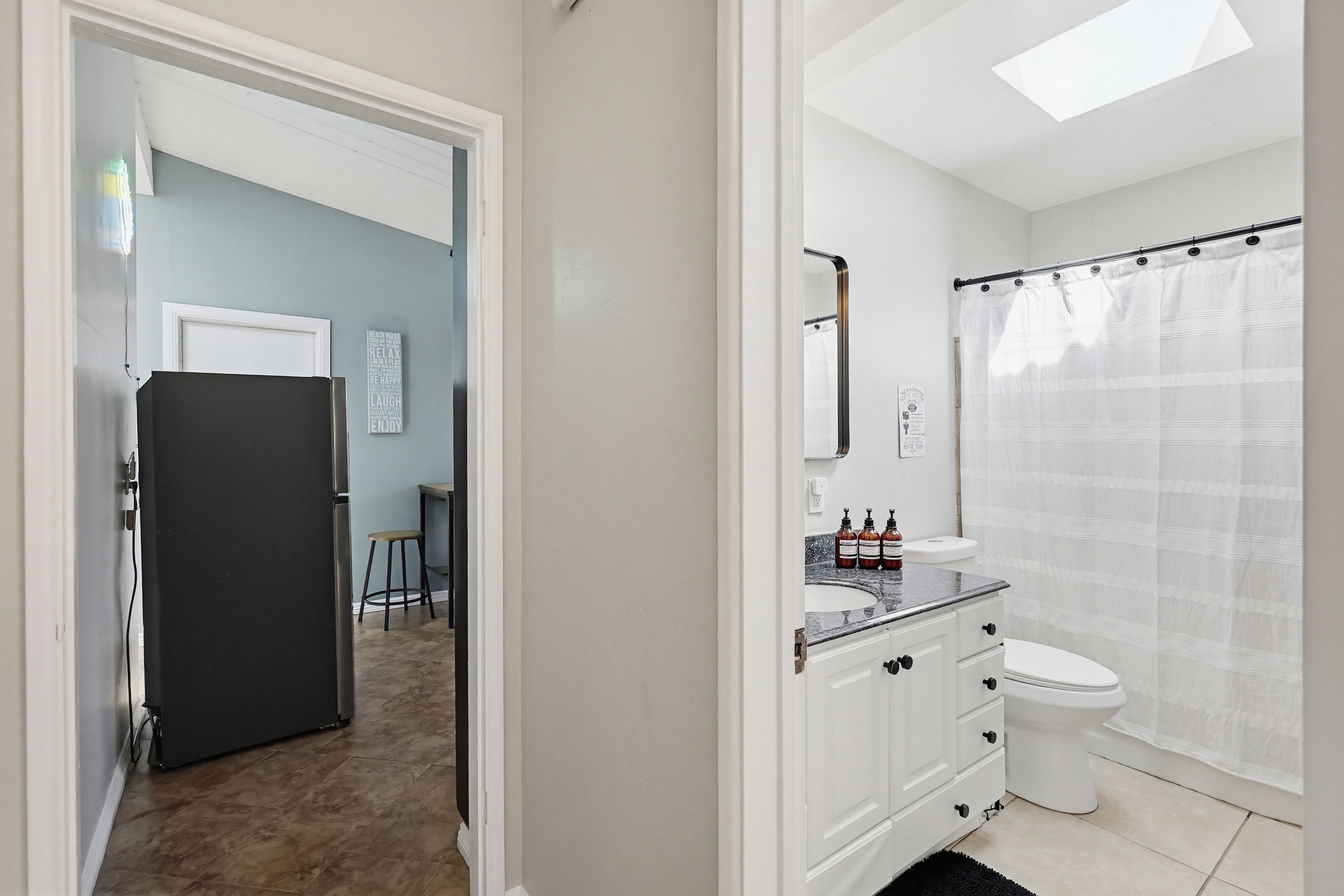 A bathroom with a toilet, sink, and shower curtain.