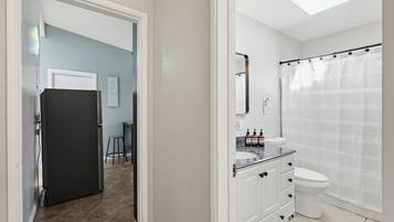 A bathroom with a toilet, sink, and shower curtain.