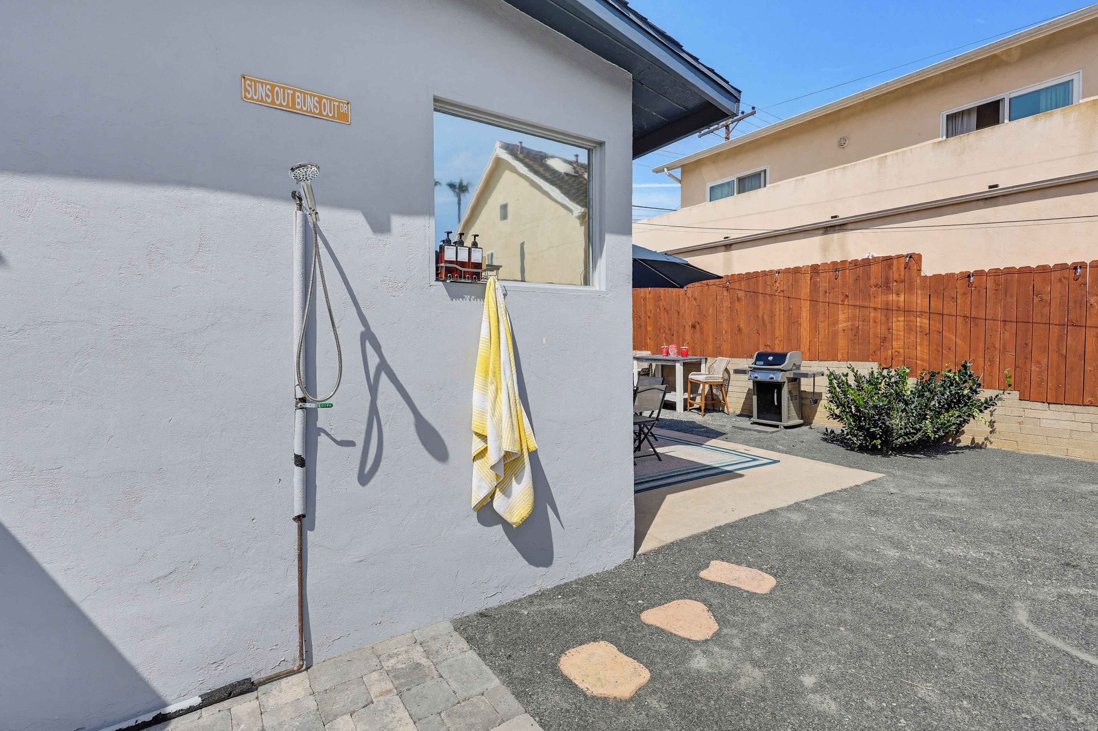 A residential building with a window, a hose, and a towel hanging on the wall.