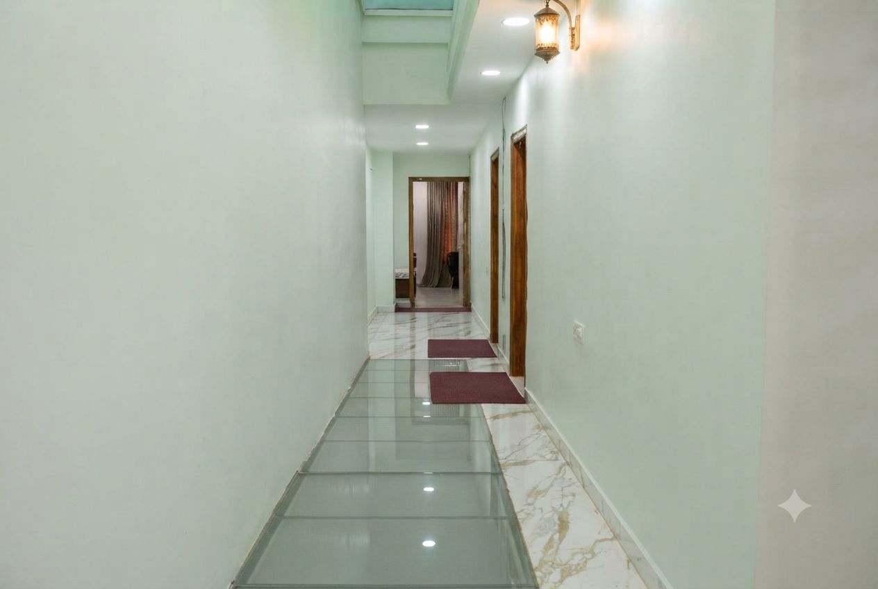 A hallway with a glass floor, a wooden door, and a wall-mounted light fixture.
