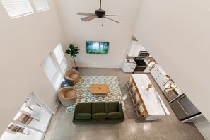 A compact kitchen with a dining area, a ceiling fan, and a large window. - Jambalaya Row | 3 Private Homes | 7BR | Sleeps 15 (Lafayette)
