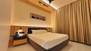 Ein Hotelzimmer mit Bett, Nachttisch und einem an der Wand hängenden Kunstwerk.