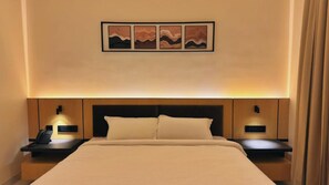Ein Hotelzimmer mit einem Bett, Nachttischen, einem Telefon und einem an der Wand hängenden Kunstwerk.