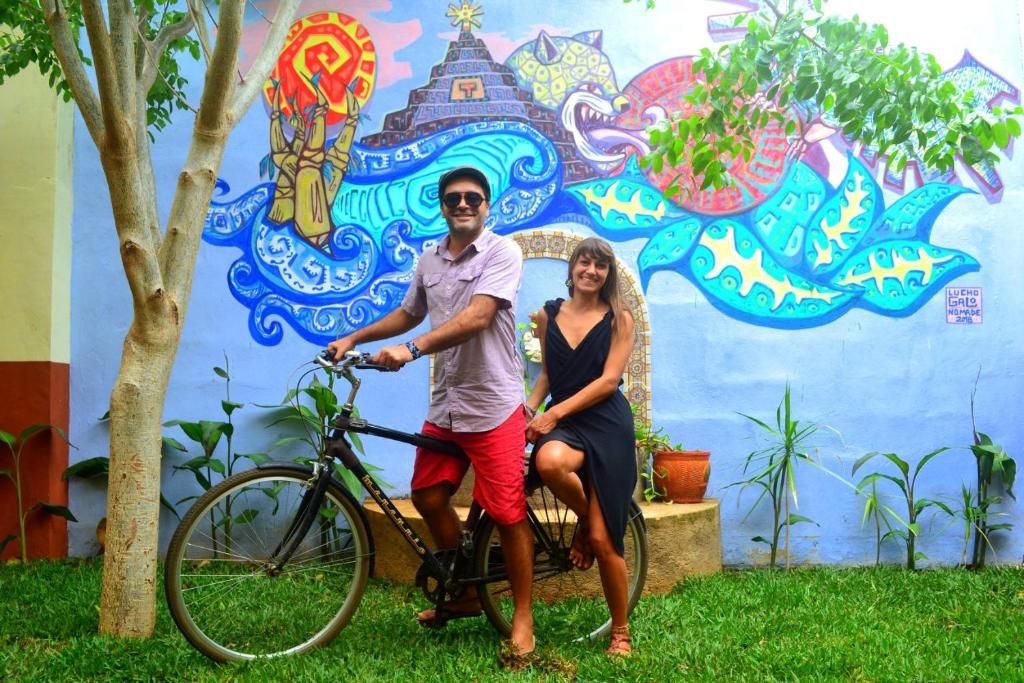 A mural with a colorful design, a bicycle, and a person standing next to it.