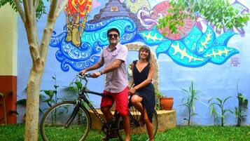 A mural with a colorful design, a bicycle, and a person standing next to it.