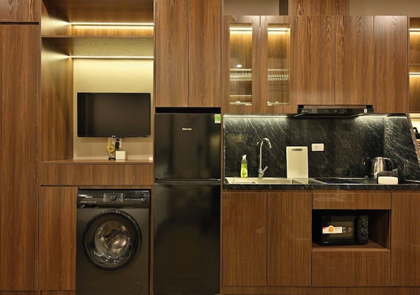 A modern kitchen with a built-in washer, refrigerator, and microwave.