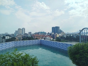 A rooftop swimming pool with a cityscape view.