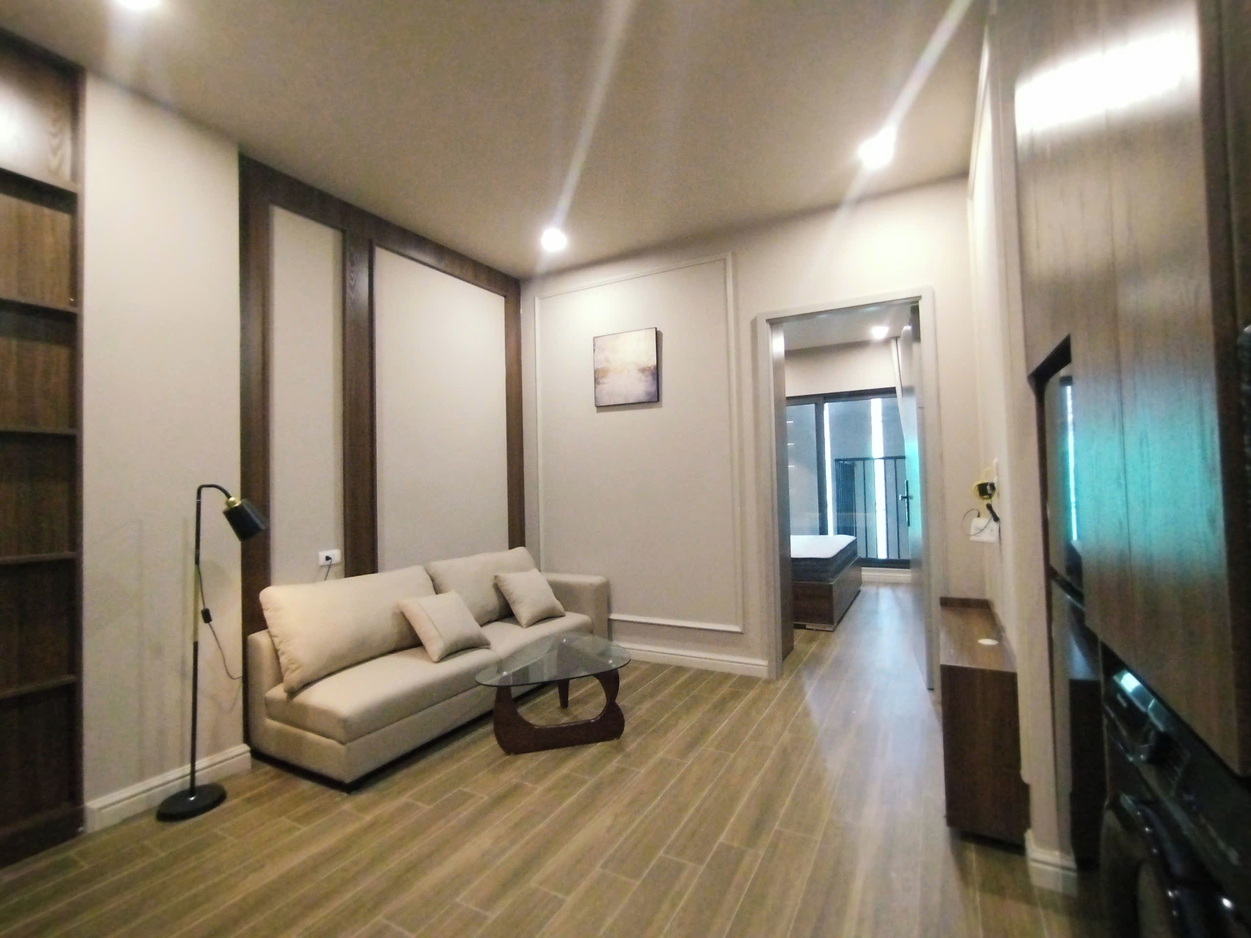 Uma sala de estar moderna com um sofá, uma mesa de centro e uma televisão.