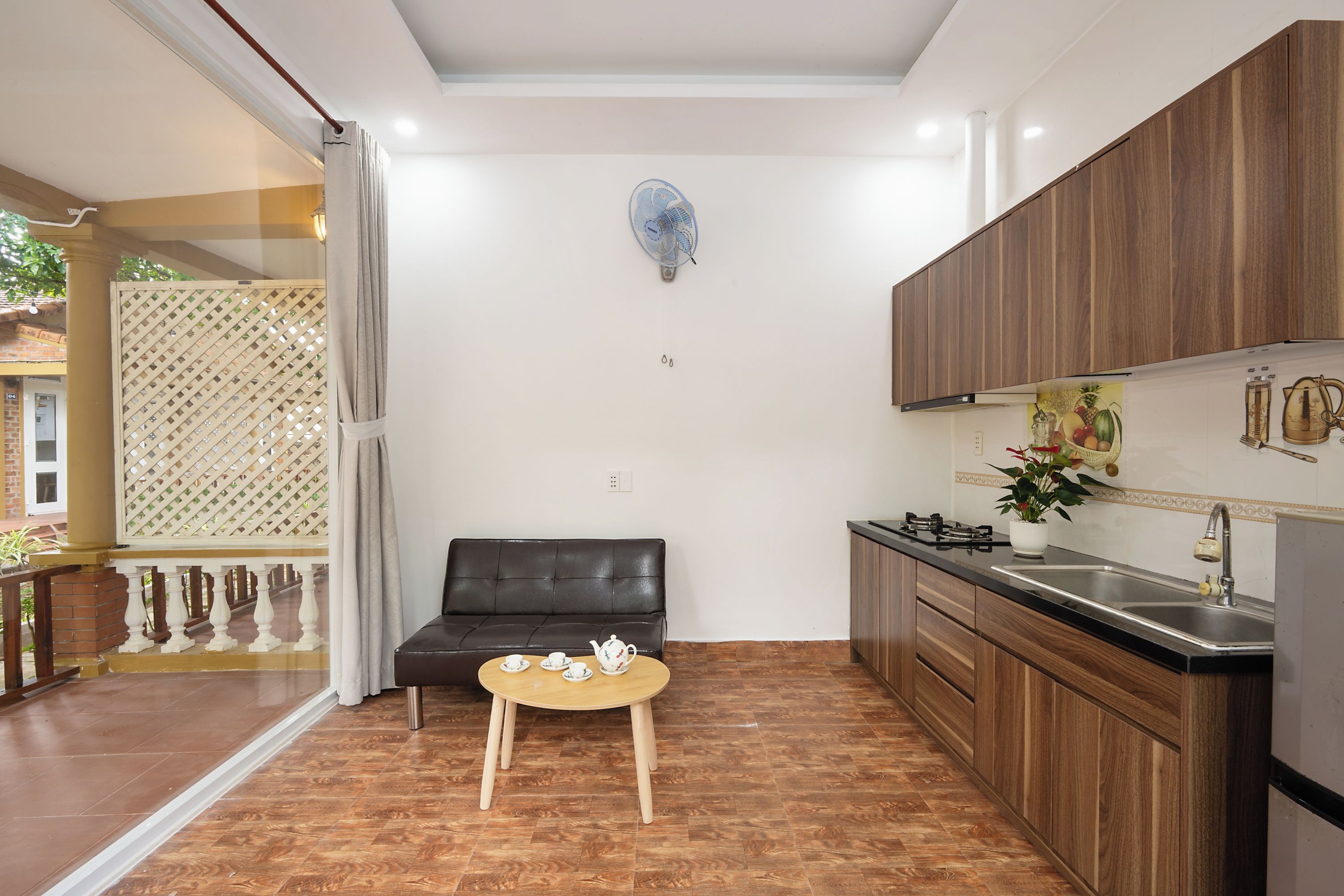 A compact kitchen with a dining area, a small table, and a sofa.