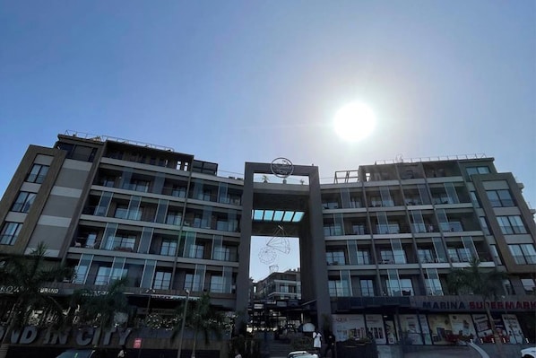 A multi-story building with a central archway, balconies, and storefronts.