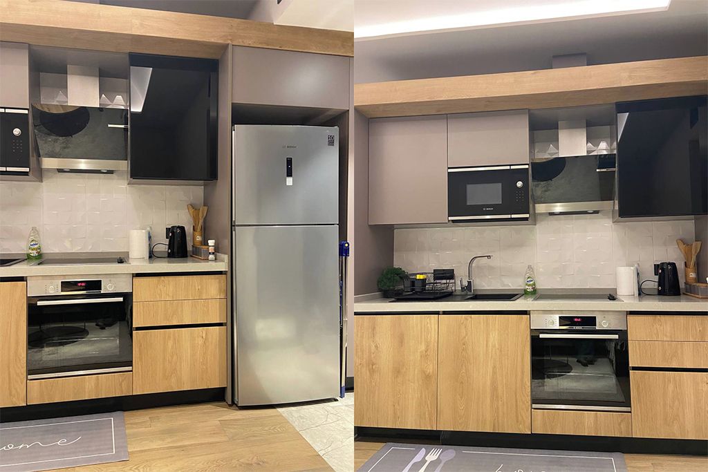 Une cuisine moderne dotée d’appareils électroménagers en acier inoxydable, de meubles en bois et d’un four encastré.