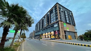 A multi-story hotel with a modern facade, large windows, and a prominent entrance. - Serenity SkyParkOne Luxury 2BR Apartment (Islamabad)