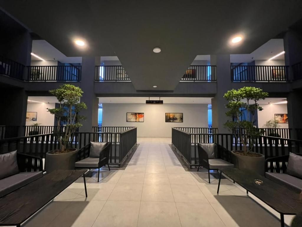 Eine geräumige Lobby mit einer zentralen Sitzecke, Blumentöpfen und modernem Design.