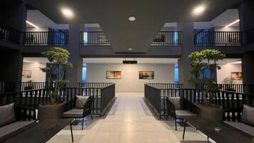 Eine geräumige Lobby mit einer zentralen Sitzecke, Blumentöpfen und modernem Design.