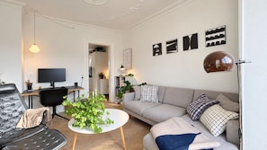A modern living room with a sofa, a coffee table, a TV, and a desk. - City Apartment in Copenhagen with 1 bedrooms sleeps 2 (Copenhagen)