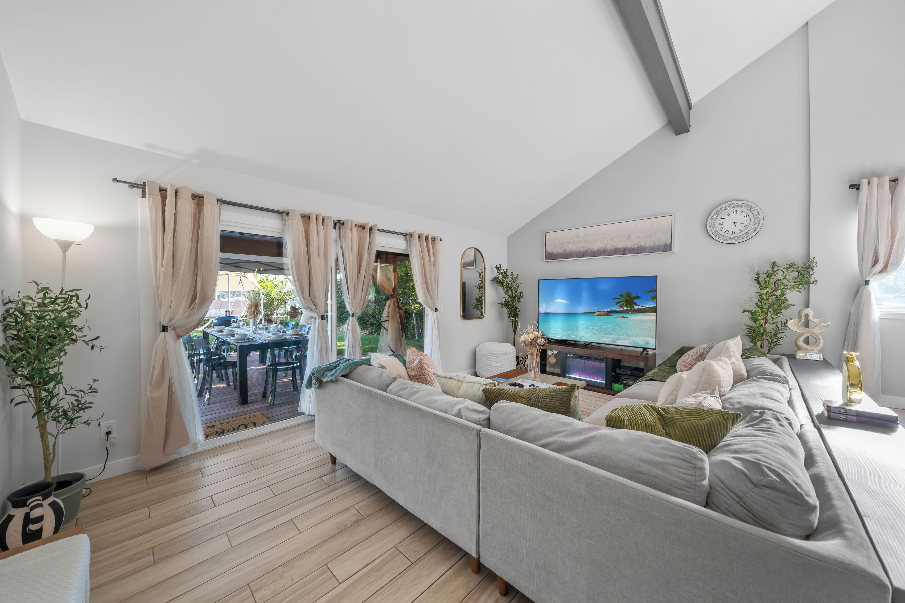 Ein modernes Wohnzimmer mit Sofa, Fernseher und Essbereich.