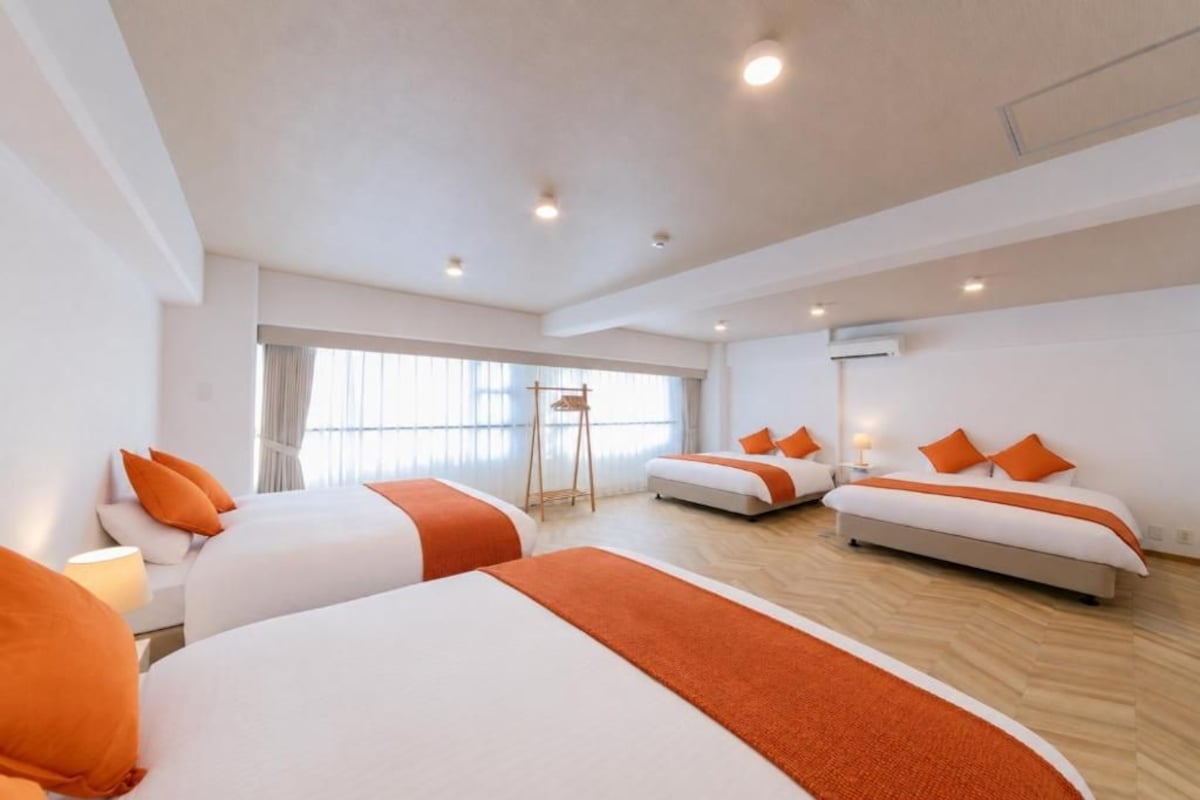 Habitació d'hotel amb dos llits, una taula petita i una cadira.