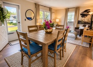 A dining area with a wooden table, blue cushioned chairs, and a vase of flowers. - Charming 3 bedroom home near Galleria - Prime Location! (Minneapolis)