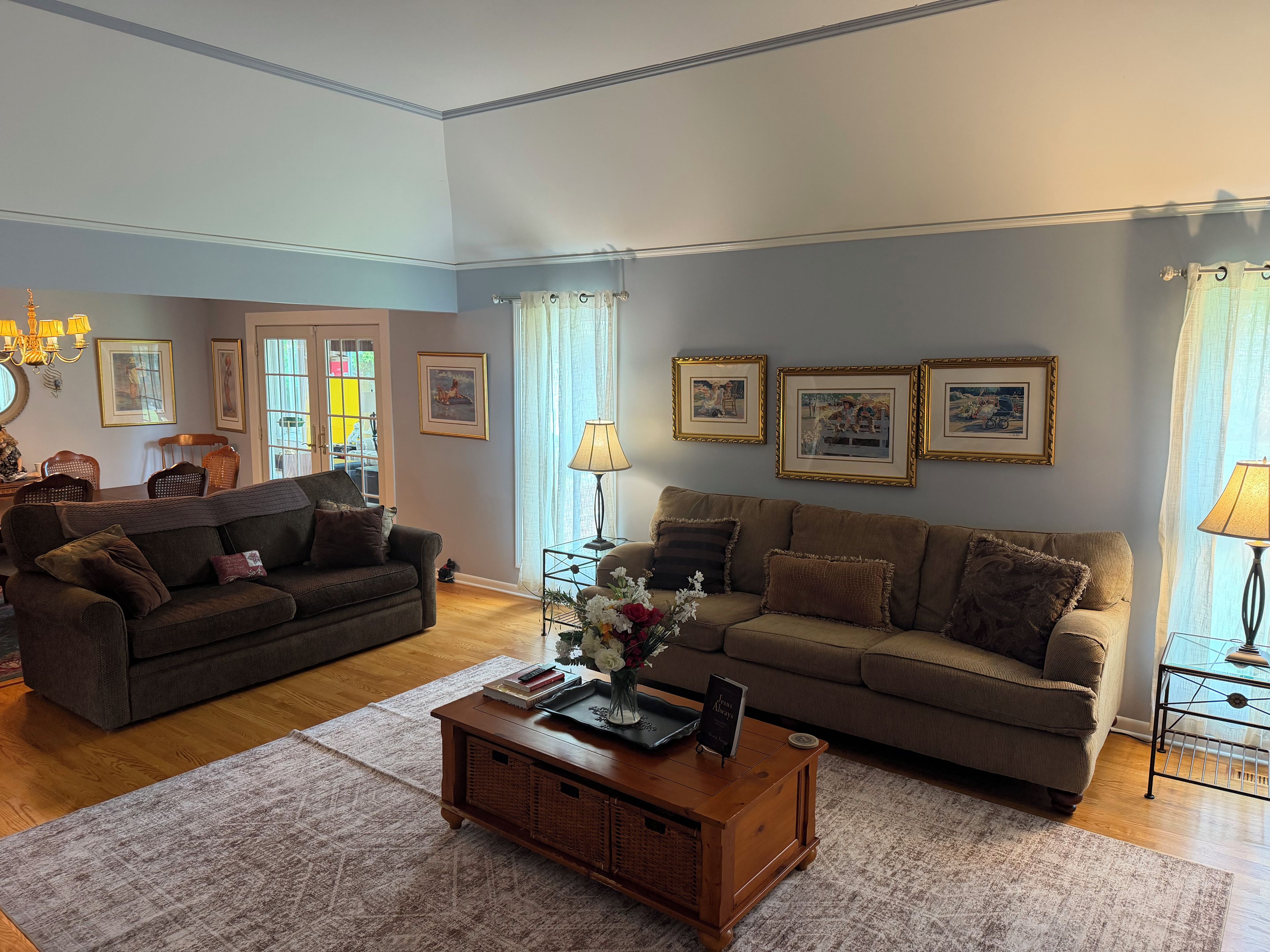A living room with two sofas, a coffee table, and framed pictures on the wall.