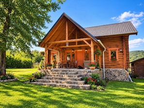 A log cabin with a stone staircase leading to a porch, surrounded by a well-maintained lawn and trees. - Traditional Wooden Cottage with private garden situated in Campu Cetatii (Câmpu Cetăţii)