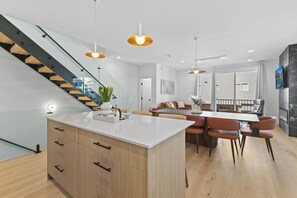 A modern kitchen with a central island, wooden cabinets, and a staircase. - Brand New!~Lux~Skyline Views~4 bedrooms (Seattle)