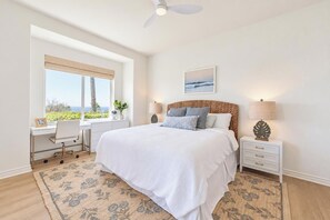 A bedroom with a large bed, a desk, and a view of the outdoors. - The Azure at Mauna Kea: Relaxed Luxury + Ocean Views + Resort Option (Kamuela)