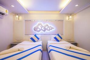 A hotel room with two beds, a decorative wall piece, and a ceiling light fixture. - siamX1 House&Bistro (Chiang Mai)