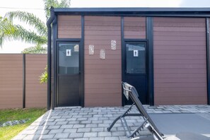 A building with two doors, each marked with a restroom symbol. - 2 adjoining country homes with 2 heated pools, 2 terraces, and a garden (Jardines de la calera)