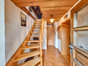 Eine hölzerne Treppe führt zu einer Tür, über der ein Schild angebracht ist.