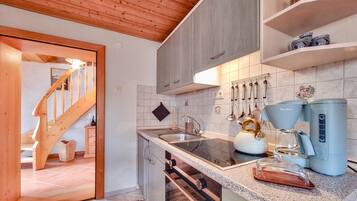 Una cocina moderna con escalera de madera, encimeras de granito y electrodomésticos de acero inoxidable.