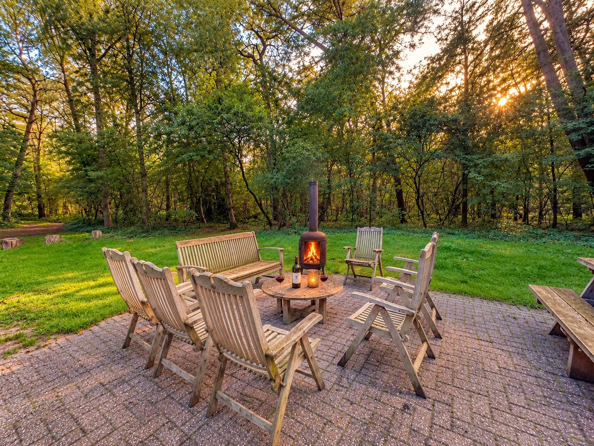 An outdoor seating area with a wood-burning stove, benches, and chairs.