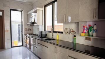 A modern kitchen with a stainless steel countertop, a built-in oven, and a window providing natural light.