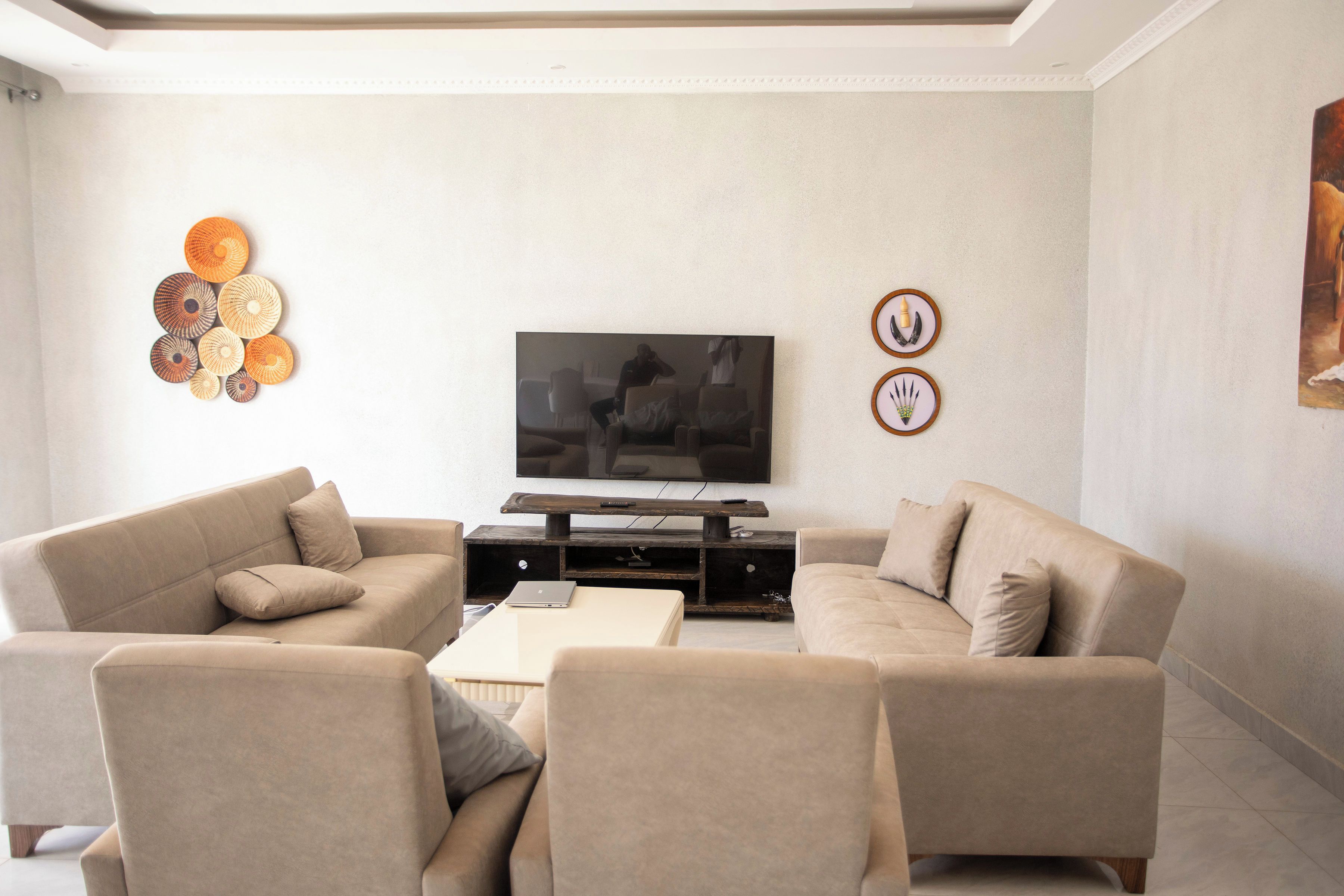 Ein Wohnzimmer mit Flachbildfernseher, zwei Sofas, einem Couchtisch und Wanddekoration.