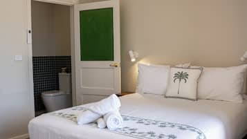 A hotel room with a bed, a bathroom, and a ceiling fan.