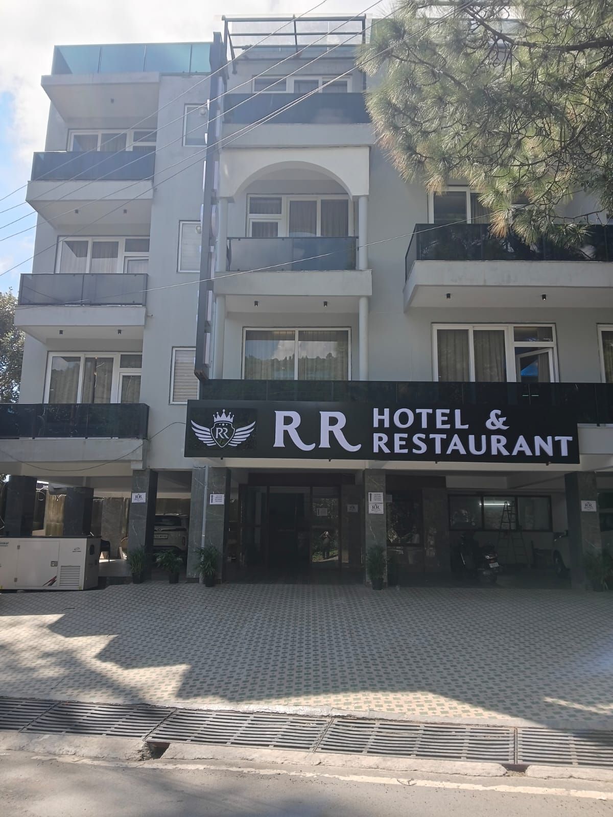 Un hotel de varios pisos con un llamativo letrero que dice 'RR Hotel & Restaurant'.