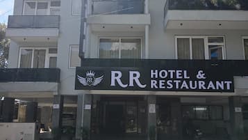 Un hotel de varios pisos con un llamativo letrero que dice 'RR Hotel & Restaurant'.
