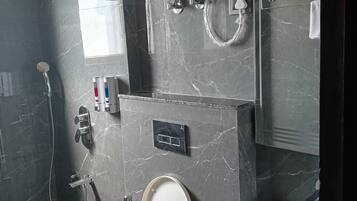 Un baño con inodoro, lavamanos, ducha y calentador de agua.