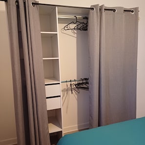 Ein begehbarer Kleiderschrank mit Kleiderstange und Regalen.