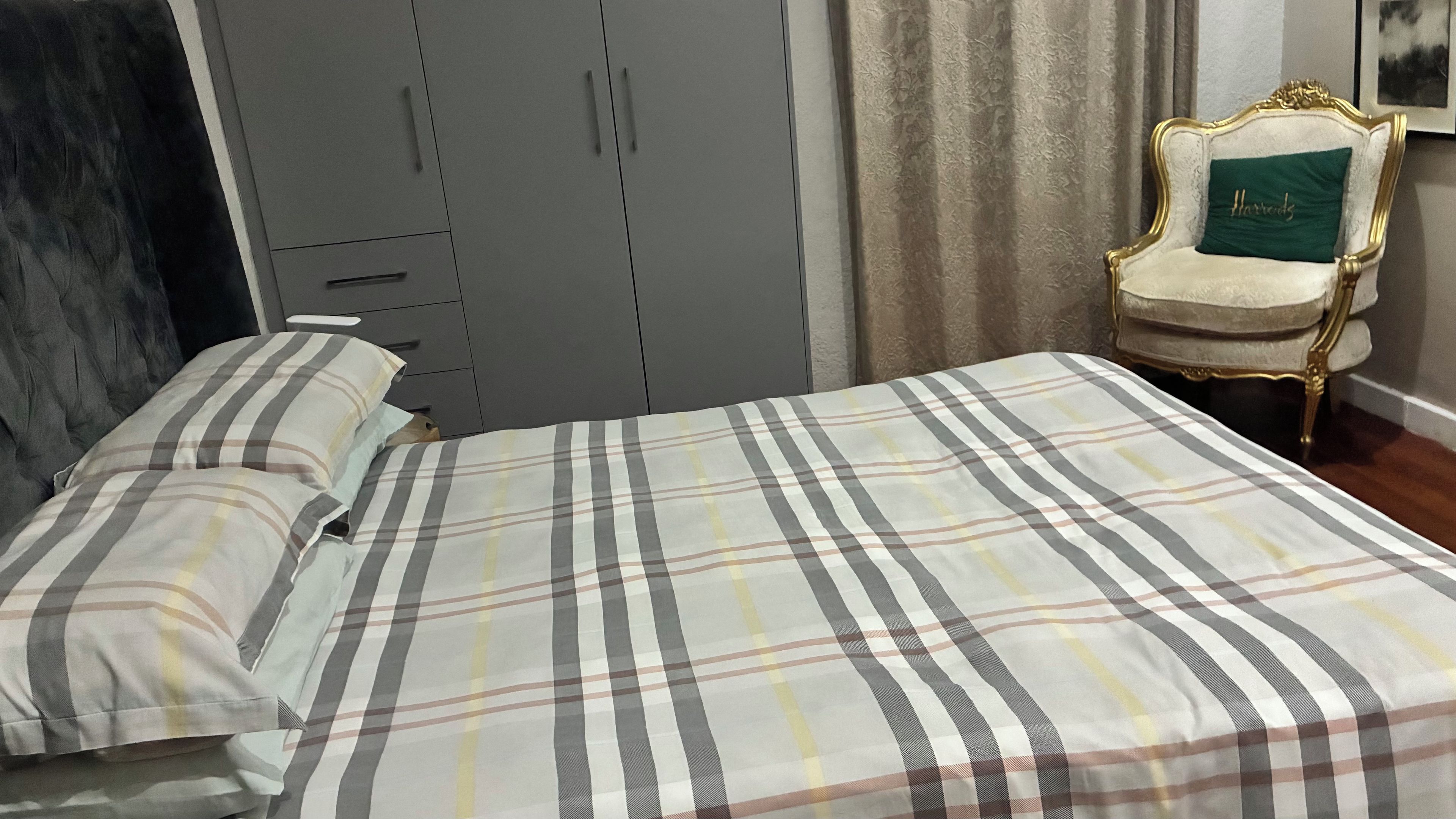 Un dormitorio con cama, armario y silla.