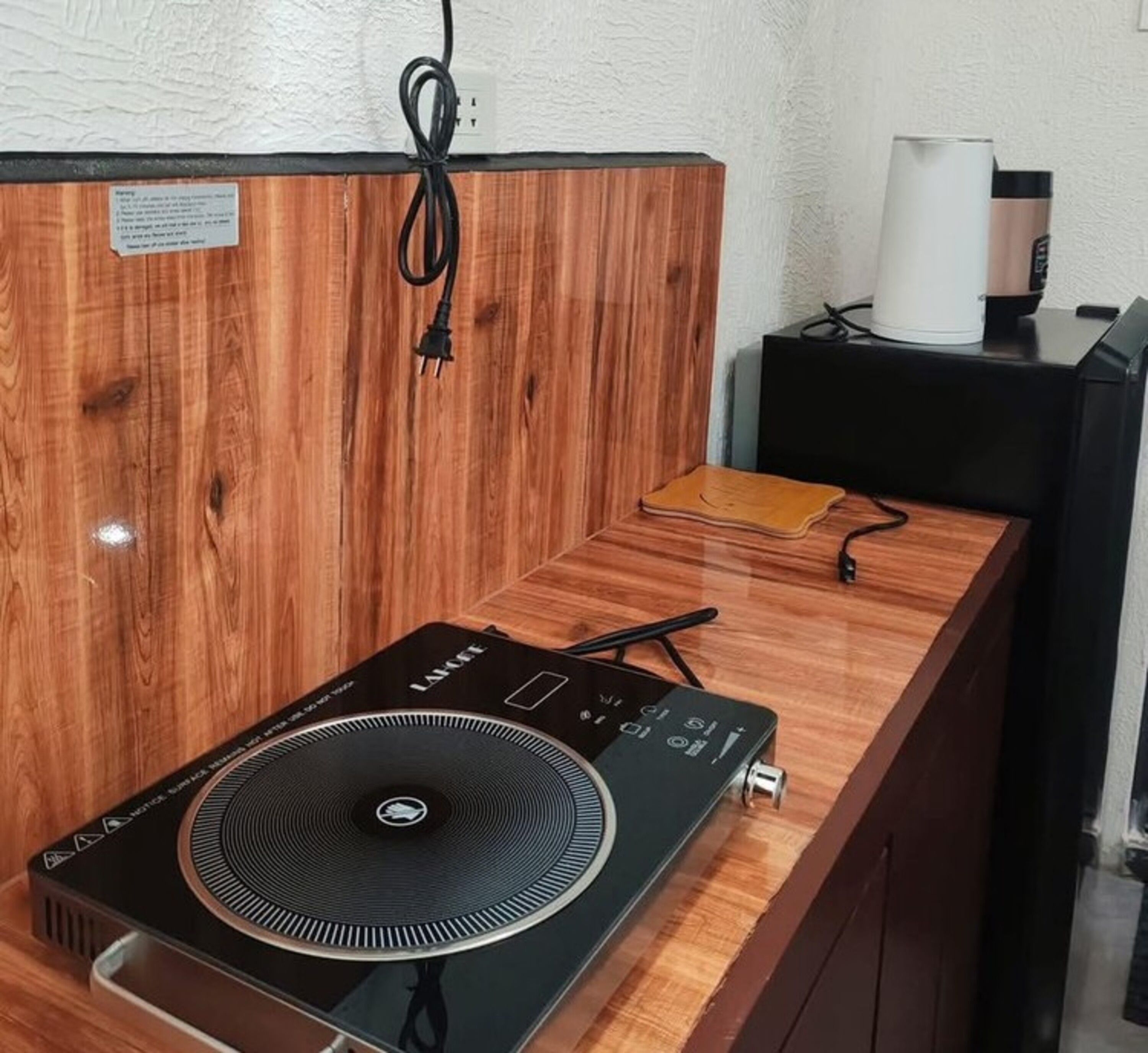 Una barra de madera con un tocadiscos y un altavoz negro.