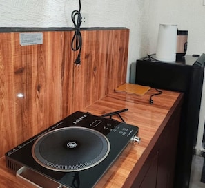 Una barra de madera con un tocadiscos y un altavoz negro.