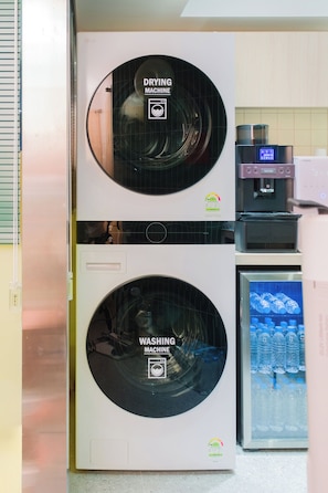 A compact, wall-mounted washer and dryer unit with a digital display and a water dispenser. - MING STAY Gangnam (Seoul)