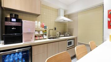 Una cocina moderna equipada con cafetera, microondas y dispensador de agua.